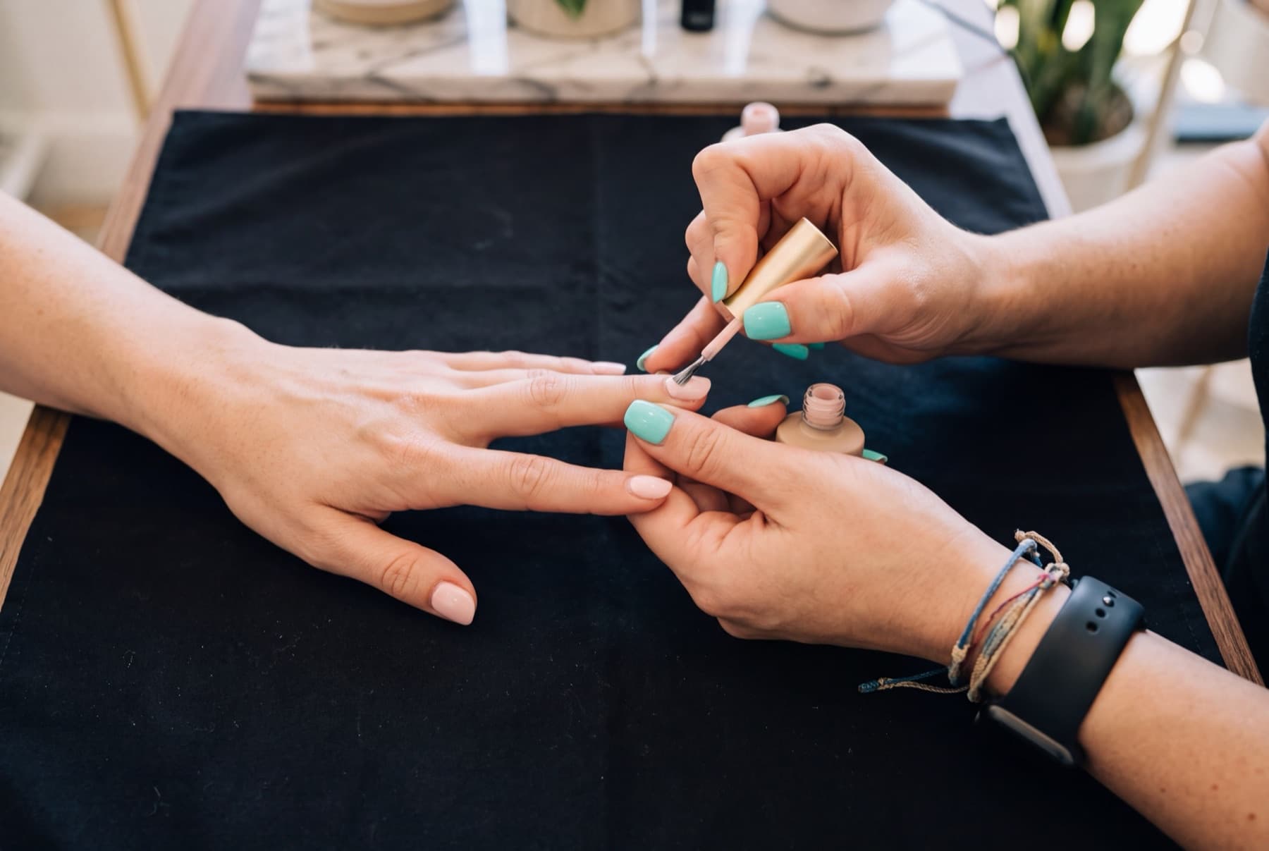 A nail technician painting a client's nails